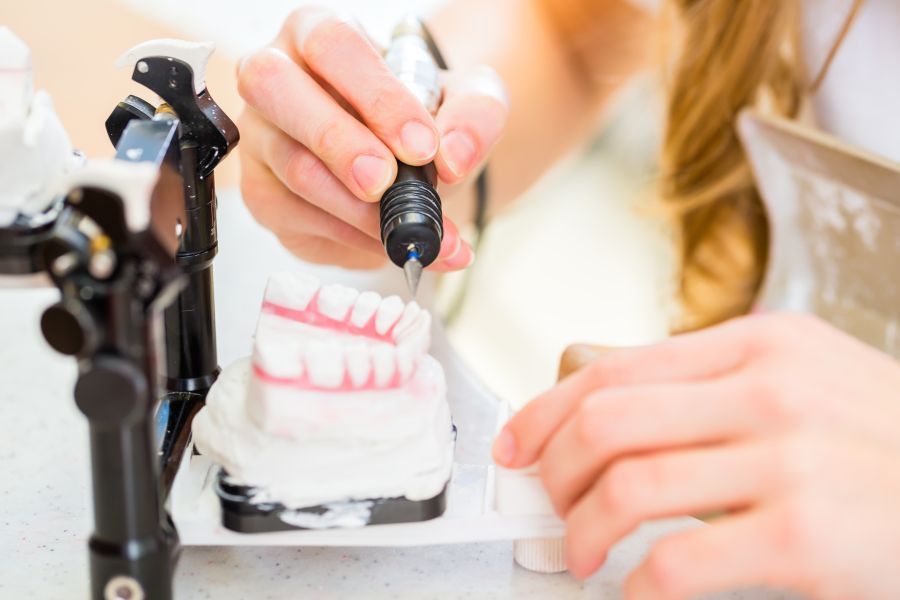 Dental technician producing denture